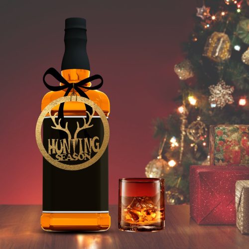 Hunting Season wooden Christmas ornament displayed on a whiskey bottle as a unique holiday gift for hunters.