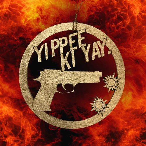 Gold wooden Die Hard Christmas ornament featuring the iconic Yippee Ki Yay quote with a pistol and bullet holes against a fiery action-themed background.